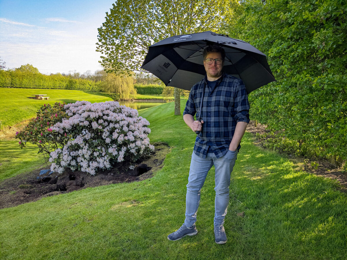 Adam holding eco-friendly umbrella above head